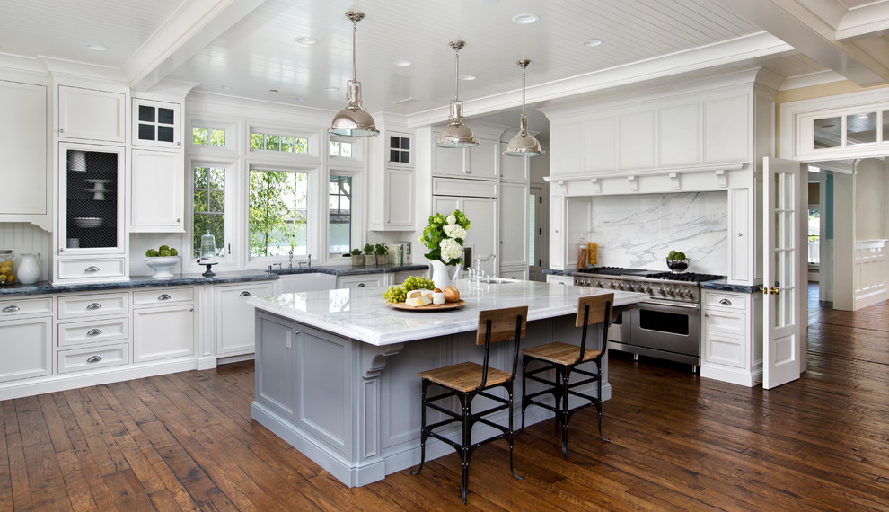 Inspiration for a large contemporary l-shaped kitchen in San Francisco with a farmhouse sink, beaded inset cabinets, white cabinets, marble benchtops, white splashback, stone slab splashback, panelled appliances, dark hardwood floors, with island and brown floor.