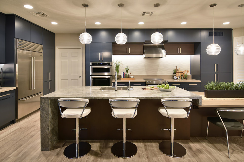 Large transitional eat-in kitchen in Phoenix with an undermount sink, flat-panel cabinets, blue cabinets, quartz benchtops, white splashback, porcelain splashback, stainless steel appliances, porcelain floors, with island and beige floor.