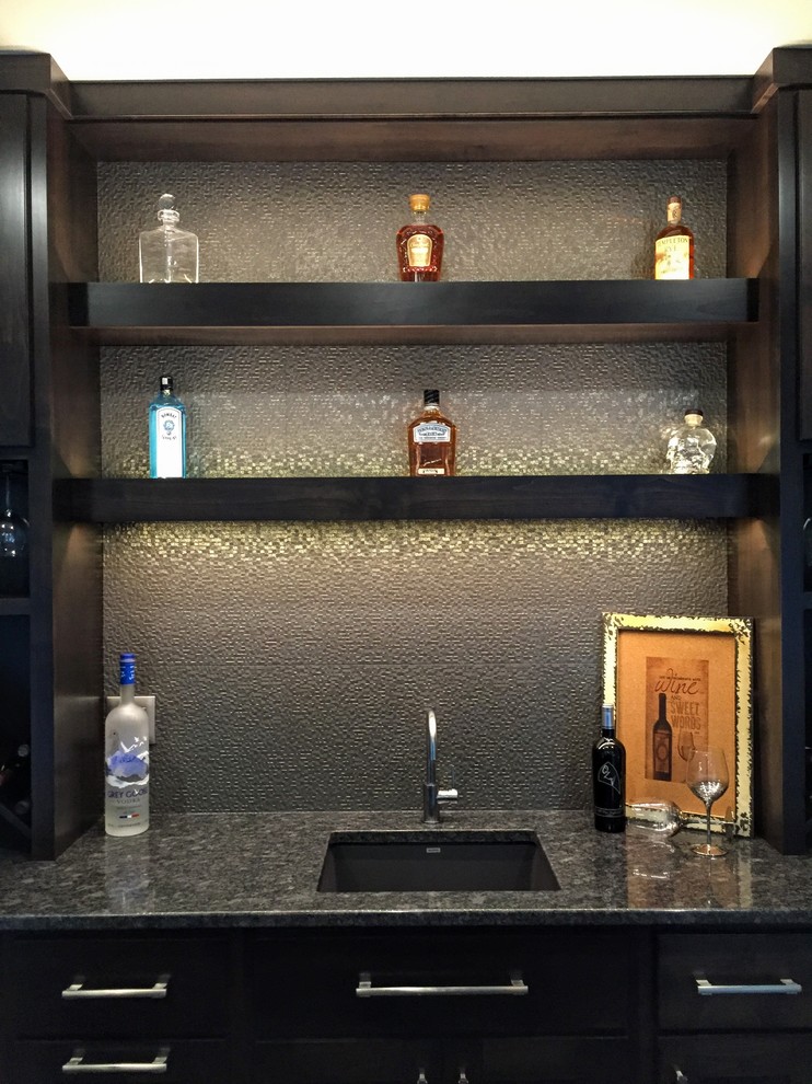 Inspiration for a mid-sized contemporary single-wall wet bar in Cedar Rapids with grey splashback, porcelain splashback, an undermount sink, flat-panel cabinets, black cabinets and granite benchtops.