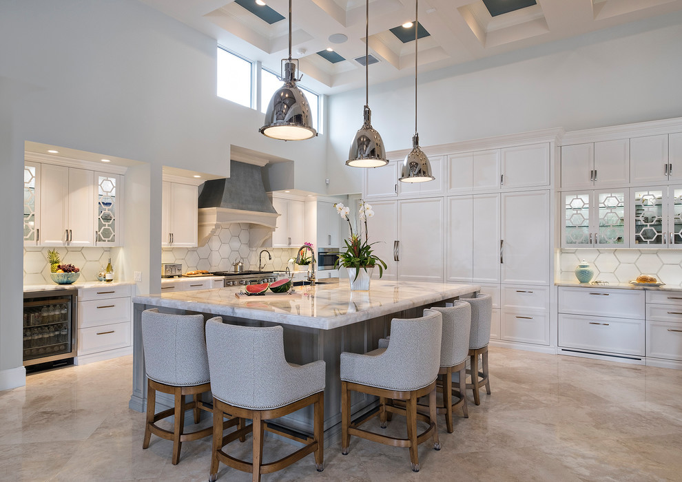 Huge transitional l-shaped beige floor eat-in kitchen photo in Miami with white cabinets, white backsplash, stainless steel appliances, an island, marble countertops, porcelain backsplash, white countertops and recessed-panel cabinets