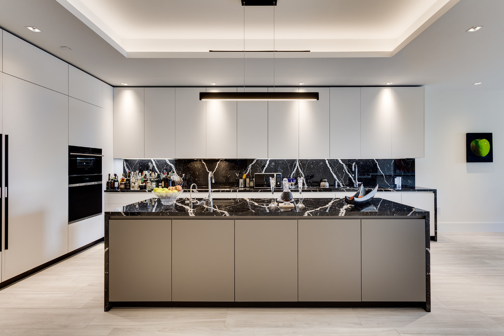 Large contemporary l-shaped open plan kitchen in Miami with an undermount sink, flat-panel cabinets, ceramic floors, with island, beige floor, black splashback, black appliances and black benchtop.