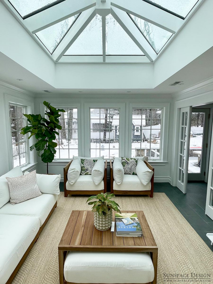 Medium sized traditional conservatory in Boston with slate flooring, a standard fireplace, a stone fireplace surround, a glass ceiling and black floors.