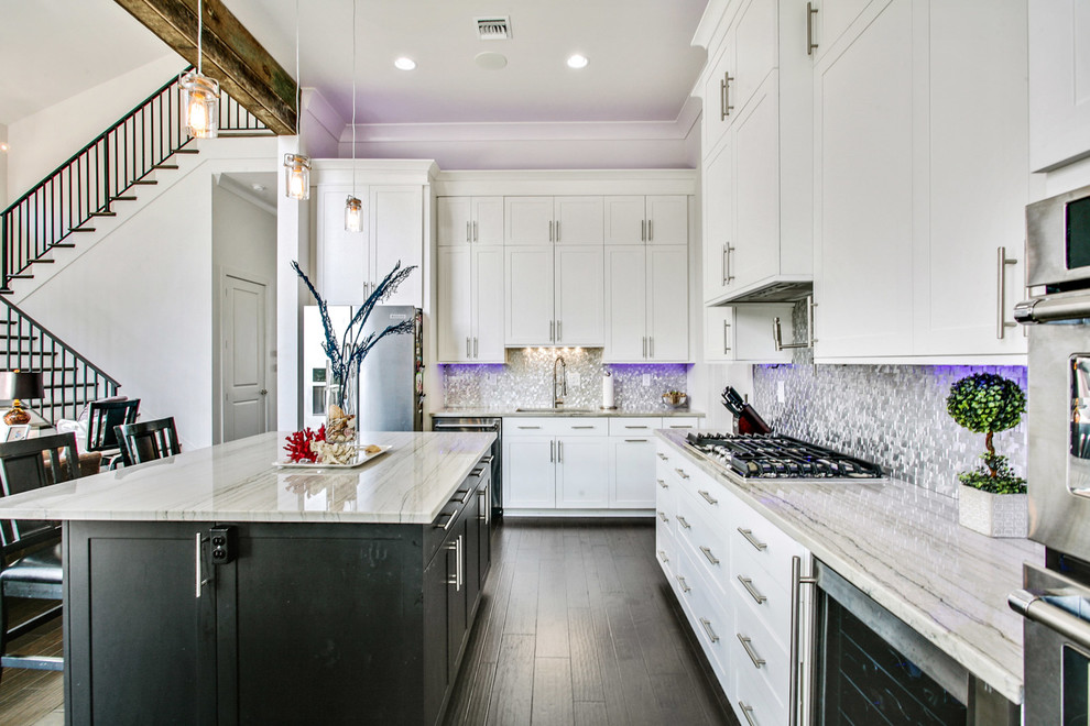 Inspiration for a transitional kitchen in New Orleans with shaker cabinets, white cabinets, metallic splashback, mosaic tile splashback, stainless steel appliances, dark hardwood floors and with island.