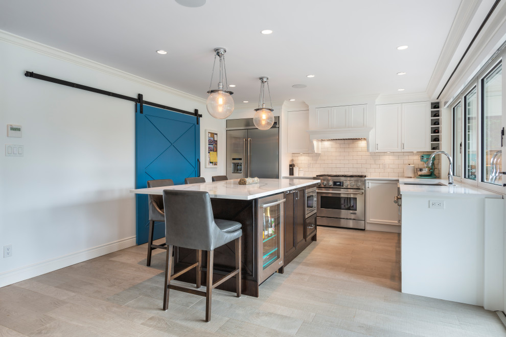 Inspiration for a transitional beige floor kitchen remodel in Vancouver with white backsplash, stainless steel appliances, an island and white countertops