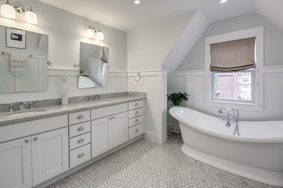 This is an example of a mid-sized arts and crafts master bathroom in Orange County with shaker cabinets, white cabinets, white walls, medium hardwood floors, an undermount sink, marble benchtops and a freestanding tub.