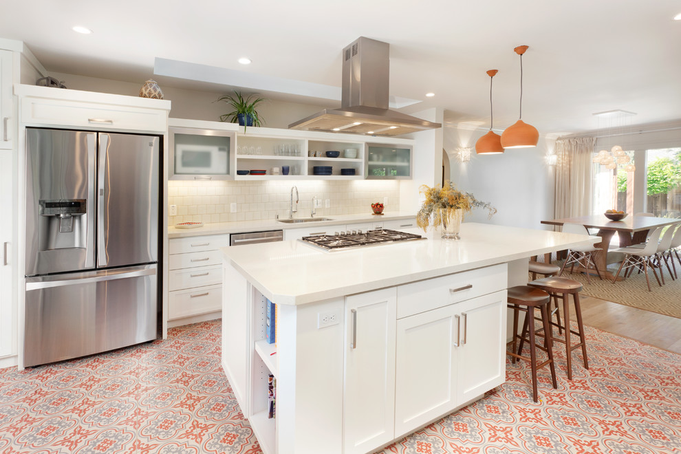 Inspiration for a mediterranean galley eat-in kitchen in San Francisco with shaker cabinets, white cabinets, solid surface benchtops, white splashback, ceramic splashback, stainless steel appliances, with island, an undermount sink, ceramic floors, multi-coloured floor and white benchtop.