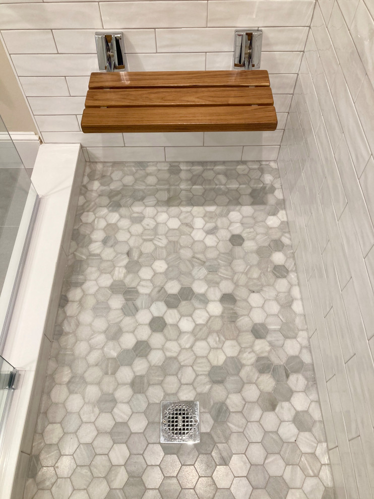 Example of a large classic master beige tile and marble tile porcelain tile, beige floor and single-sink corner shower design in Boston with recessed-panel cabinets, medium tone wood cabinets, a bidet, blue walls, an undermount sink, quartz countertops, a hinged shower door, beige countertops, a niche and a built-in vanity