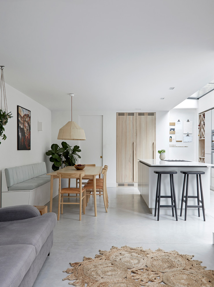 Photo of a large scandinavian open plan dining in London with concrete floors and grey floor.