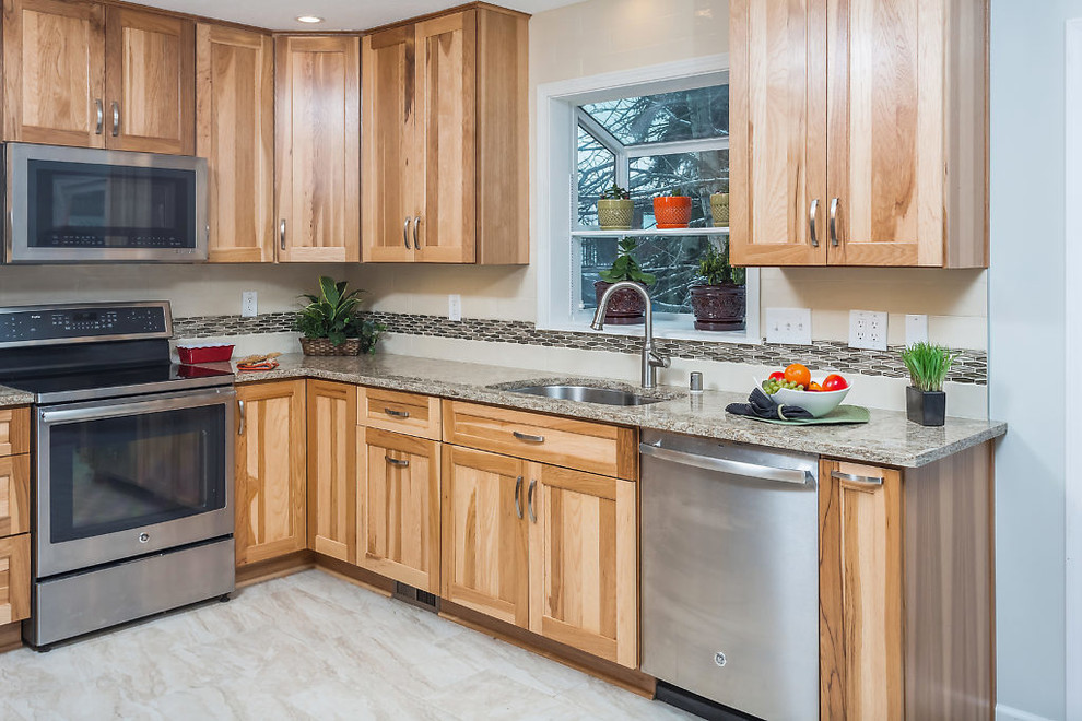 Inspiration for a mid-sized transitional u-shaped enclosed kitchen remodel with an undermount sink, shaker cabinets, light wood cabinets, quartz countertops, white backsplash, subway tile backsplash, stainless steel appliances and no island