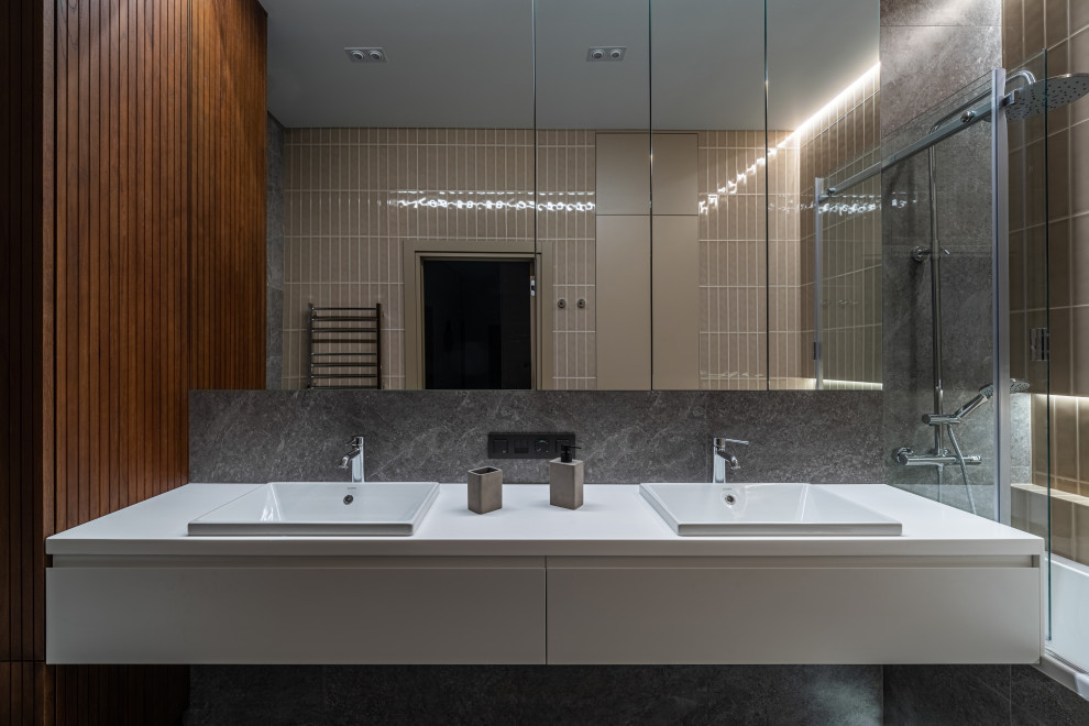 Inspiration for a mid-sized bathroom in Saint Petersburg with flat-panel cabinets, dark wood cabinets, an undermount tub, a bidet, gray tile, slate, grey walls, marble floors, an undermount sink, limestone benchtops, grey floor, white benchtops, a double vanity, a floating vanity and wood walls.