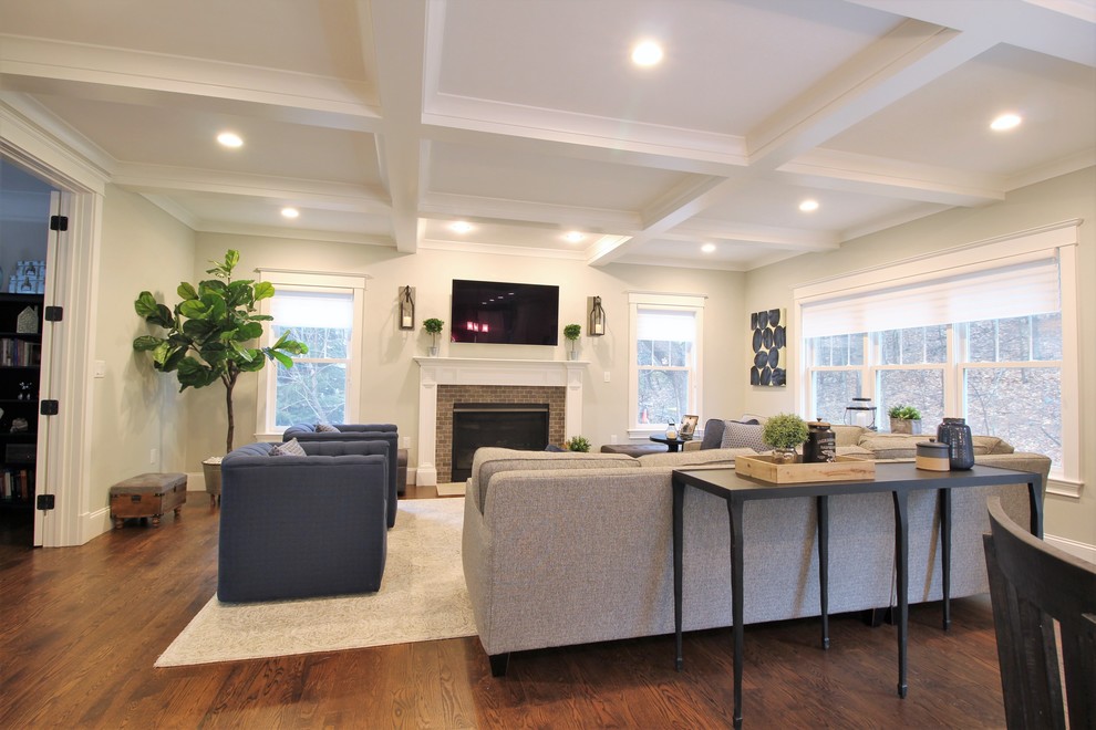 Inspiration for a large transitional open concept dark wood floor and gray floor living room remodel in Boston with gray walls, a standard fireplace, a brick fireplace and a wall-mounted tv