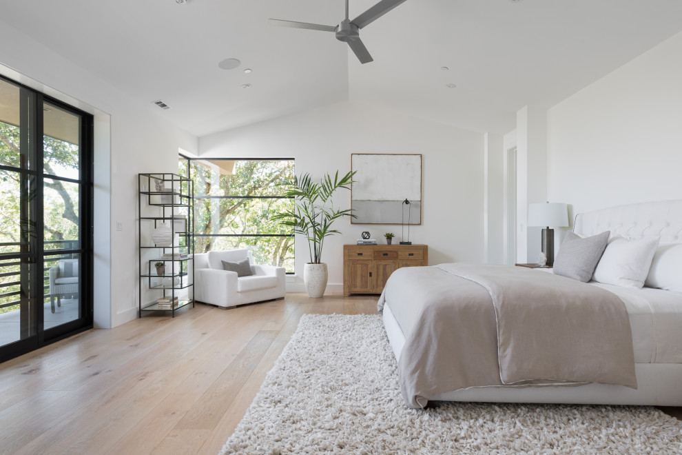 Design ideas for a transitional bedroom in San Francisco with white walls, light hardwood floors, beige floor and vaulted.
