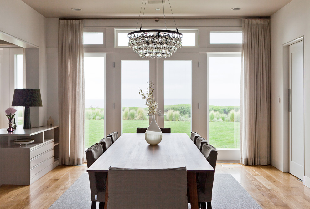 This is an example of a contemporary dining room in Los Angeles with white walls and medium hardwood floors.