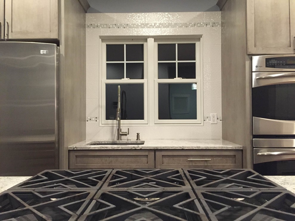 Eat-in kitchen - large transitional l-shaped medium tone wood floor eat-in kitchen idea in Grand Rapids with a farmhouse sink, shaker cabinets, gray cabinets, quartz countertops, white backsplash, porcelain backsplash, stainless steel appliances and an island