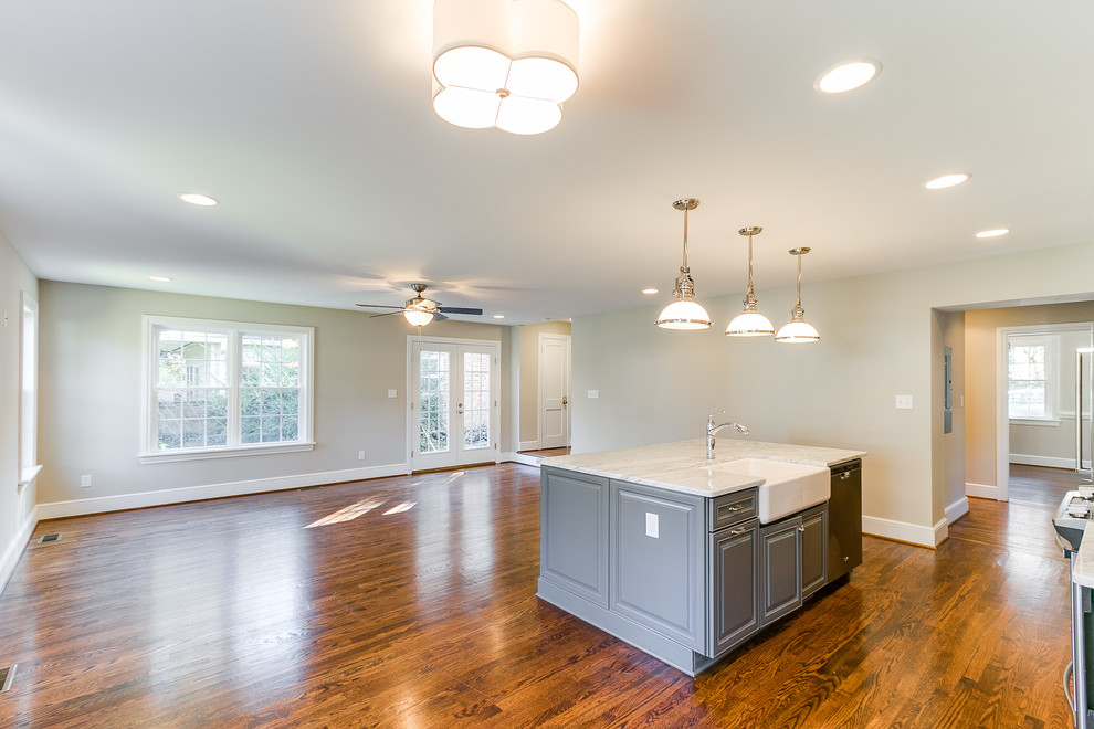Example of a single-wall medium tone wood floor eat-in kitchen design in Richmond with a farmhouse sink, glass-front cabinets, white cabinets, marble countertops, white backsplash, subway tile backsplash, stainless steel appliances and an island