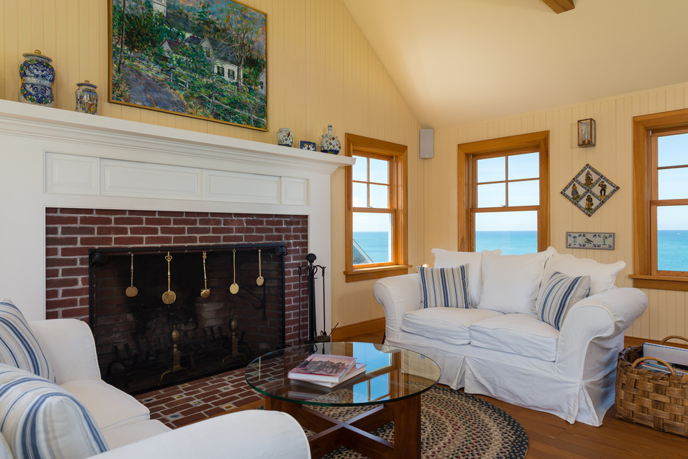 Inspiration for a large beach style open concept living room in Boston with yellow walls, medium hardwood floors, a standard fireplace and a brick fireplace surround.