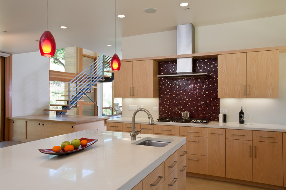 Design ideas for a contemporary kitchen in San Francisco with flat-panel cabinets, light wood cabinets, red splashback, stainless steel appliances, mosaic tile splashback and white benchtop.