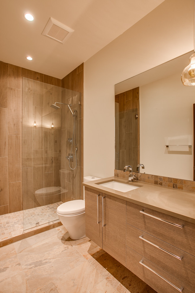 This is an example of a mid-sized modern 3/4 bathroom in Seattle with flat-panel cabinets, light wood cabinets, a one-piece toilet, brown tile, porcelain tile, white walls, porcelain floors, an undermount sink and engineered quartz benchtops.