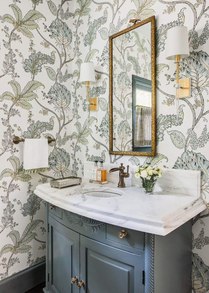 Photo of a traditional powder room in Austin with furniture-like cabinets, grey cabinets, green walls, marble benchtops, white benchtops, a freestanding vanity and wallpaper.