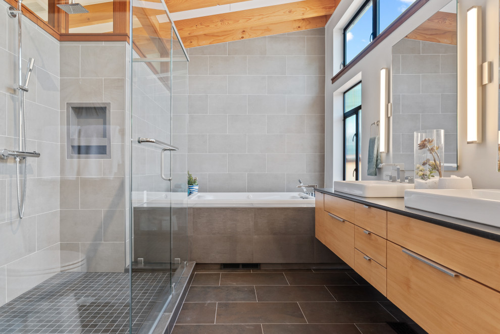 Design ideas for a mid-sized contemporary master bathroom in San Francisco with flat-panel cabinets, light wood cabinets, a drop-in tub, an open shower, gray tile, porcelain tile, cement tiles, a vessel sink, quartzite benchtops, grey floor, a hinged shower door, black benchtops, a single vanity, a floating vanity and exposed beam.