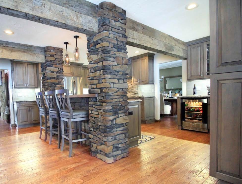 Open concept kitchen - large rustic u-shaped medium tone wood floor and brown floor open concept kitchen idea with a single-bowl sink, raised-panel cabinets, gray cabinets, granite countertops, gray backsplash, brick backsplash, stainless steel appliances and an island