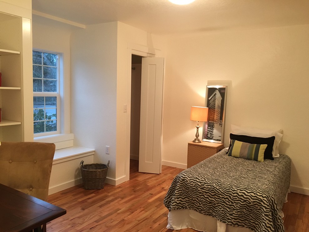 Example of a mid-sized transitional guest medium tone wood floor and brown floor bedroom design with white walls and no fireplace