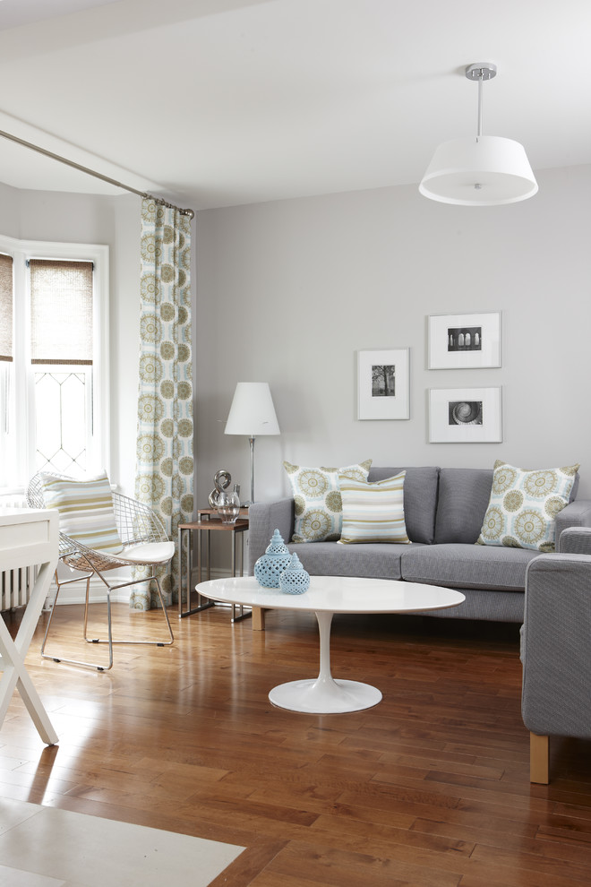 This is an example of a transitional living room in Toronto with grey walls.