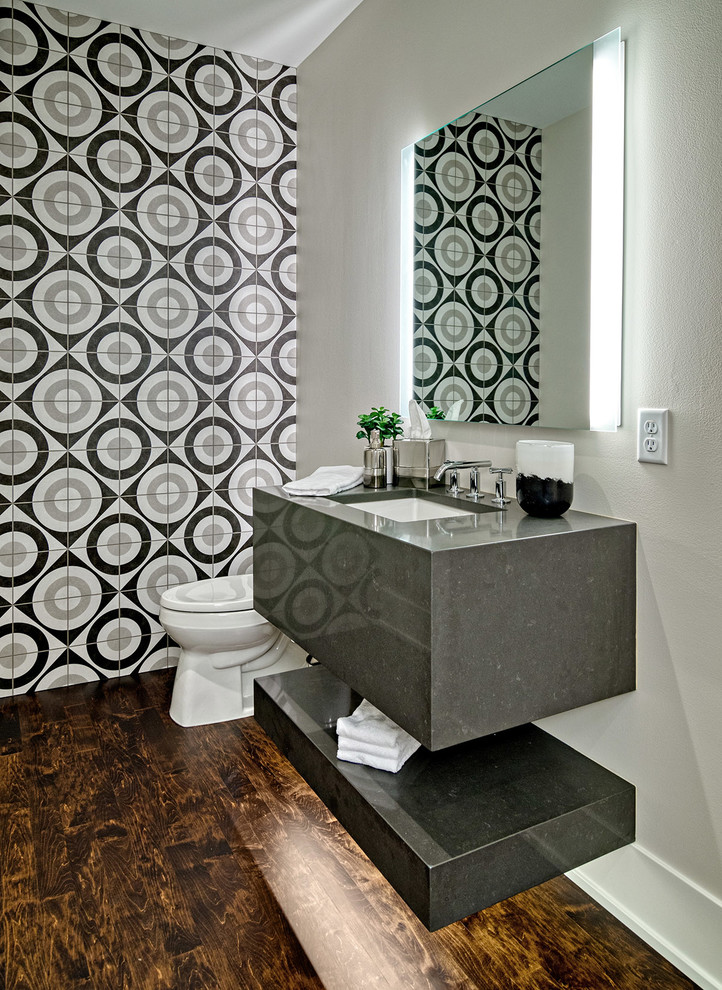 This is an example of a contemporary powder room in Minneapolis with multi-coloured tile, ceramic tile, grey walls, an undermount sink, engineered quartz benchtops, brown floor, dark hardwood floors and grey benchtops.