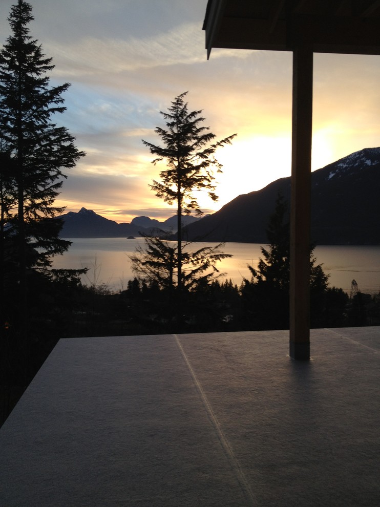 Example of a mid-sized transitional backyard deck design in Vancouver with a roof extension