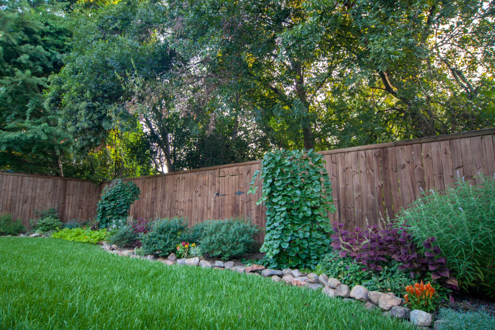 This is an example of a mid-sized transitional backyard full sun formal garden in Dallas with with flowerbed.