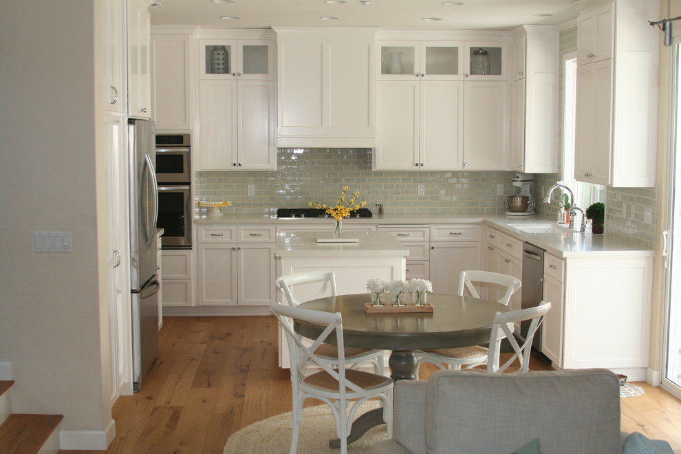 Kitchen - transitional medium tone wood floor kitchen idea with an undermount sink, recessed-panel cabinets, white cabinets, quartz countertops, blue backsplash, subway tile backsplash, stainless steel appliances and an island