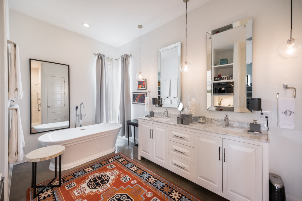 Photo of a mediterranean bathroom with raised-panel cabinets, white cabinets, a freestanding tub, grey walls, an undermount sink, grey floor, grey benchtops and a double vanity.