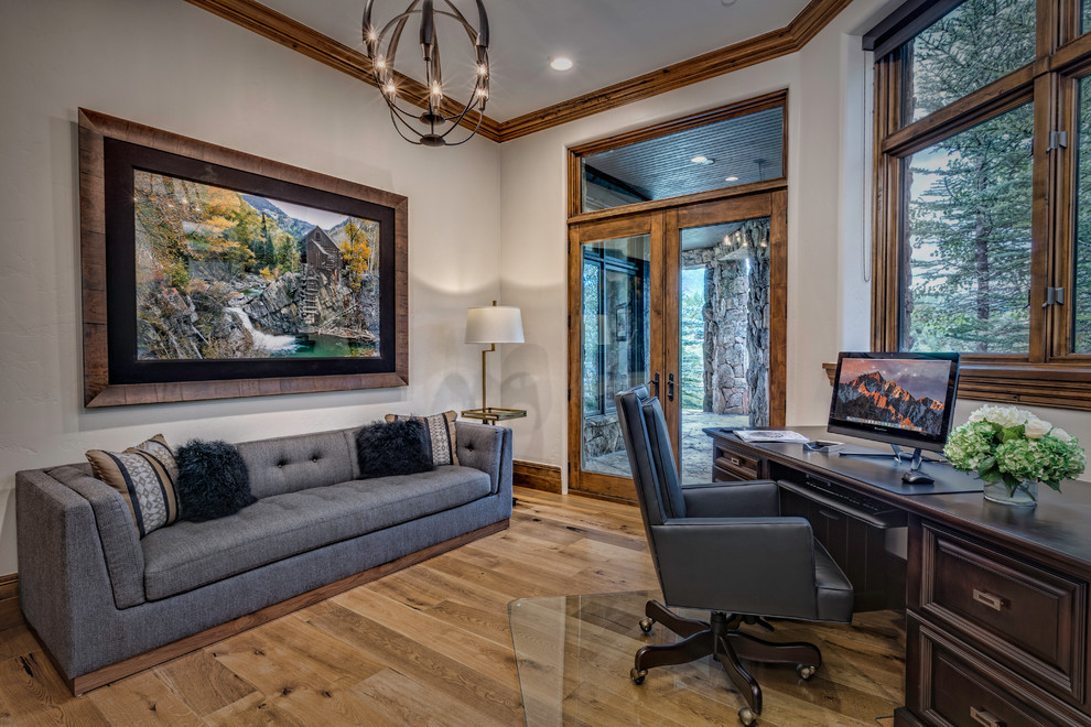 Photo of a large country study room in Denver with medium hardwood floors, beige walls, no fireplace, a freestanding desk and brown floor.