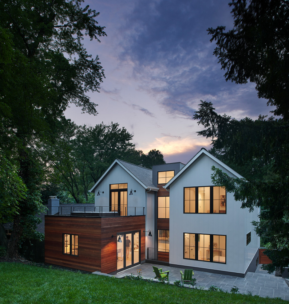 Cette image montre une grande façade de maison blanche design en bois de plain-pied avec un toit à deux pans, un toit en shingle et un toit noir.