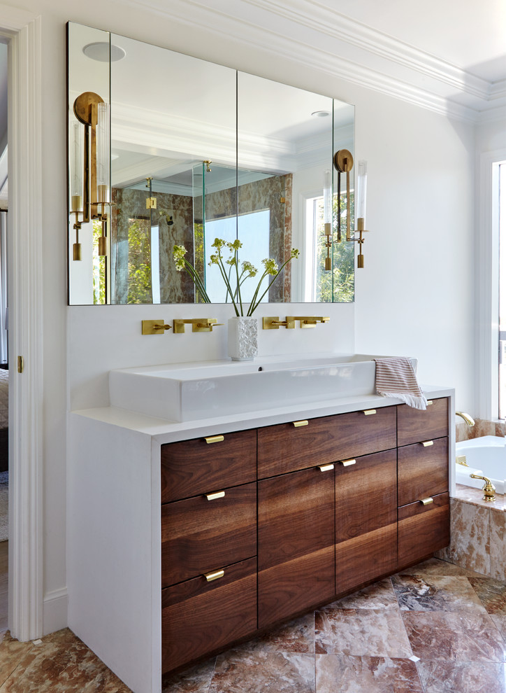 Mid-sized transitional master bathroom in San Francisco with flat-panel cabinets, medium wood cabinets, a drop-in tub, a corner shower, a two-piece toilet, beige tile, mosaic tile, white walls, marble floors, a trough sink and engineered quartz benchtops.
