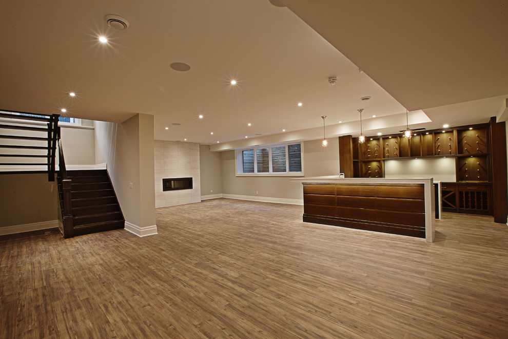 Basement - mid-sized transitional vinyl floor and brown floor basement idea in Toronto with gray walls and a standard fireplace