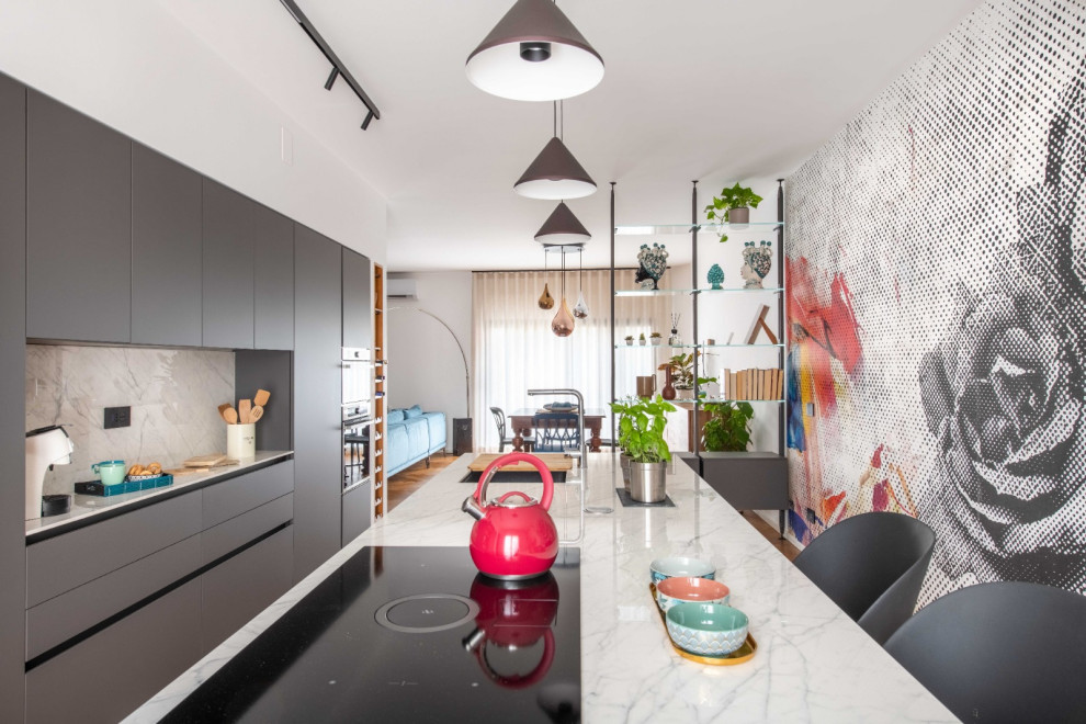 Photo of a large eclectic galley open plan kitchen in Catania-Palermo with an undermount sink, flat-panel cabinets, grey cabinets, marble benchtops, white splashback, marble splashback, stainless steel appliances, light hardwood floors, with island and white benchtop.