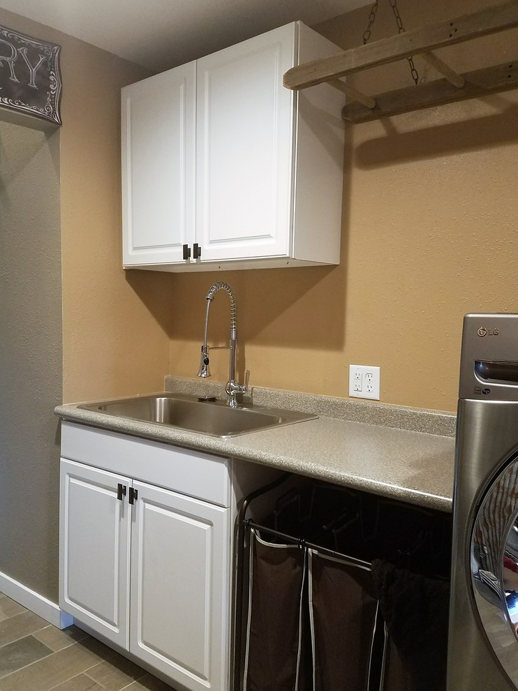 This is an example of a small country galley utility room in Other with a drop-in sink, laminate benchtops, beige walls and a side-by-side washer and dryer.