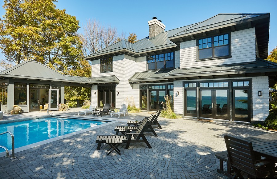 Transitional backyard brick and rectangular infinity hot tub photo in Grand Rapids