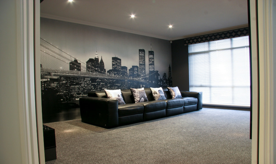 Design ideas for a mid-sized industrial enclosed home theatre in Perth with grey walls, carpet, a built-in media wall and grey floor.
