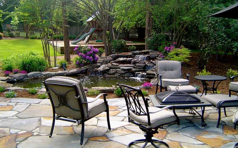 Photo of a large traditional backyard full sun garden in Charlotte with a water feature.