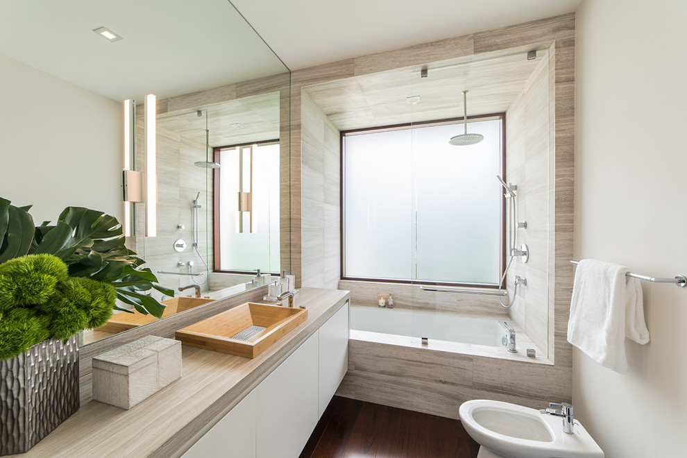 Mid-sized beach style bathroom in Miami with flat-panel cabinets, white cabinets, an undermount tub, an open shower, a bidet, gray tile, marble, white walls, dark hardwood floors, an integrated sink, engineered quartz benchtops, brown floor, an open shower and white benchtops.
