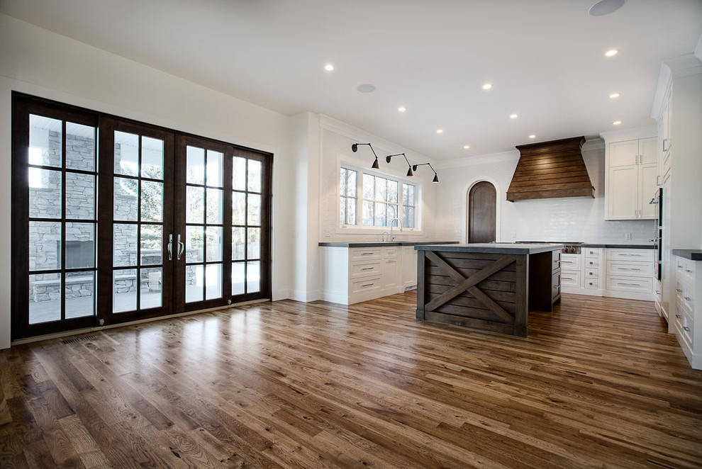 Inspiration for a large transitional u-shaped eat-in kitchen remodel in Calgary with shaker cabinets, paneled appliances and an island