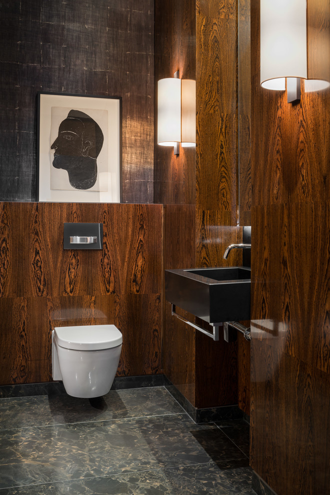 Contemporary powder room in London with a wall-mount toilet, brown walls, a vessel sink and grey floor.