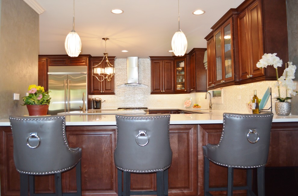 Large transitional u-shaped open concept kitchen photo in Chicago with an undermount sink, raised-panel cabinets, medium tone wood cabinets, quartz countertops, white backsplash, glass tile backsplash, stainless steel appliances and a peninsula