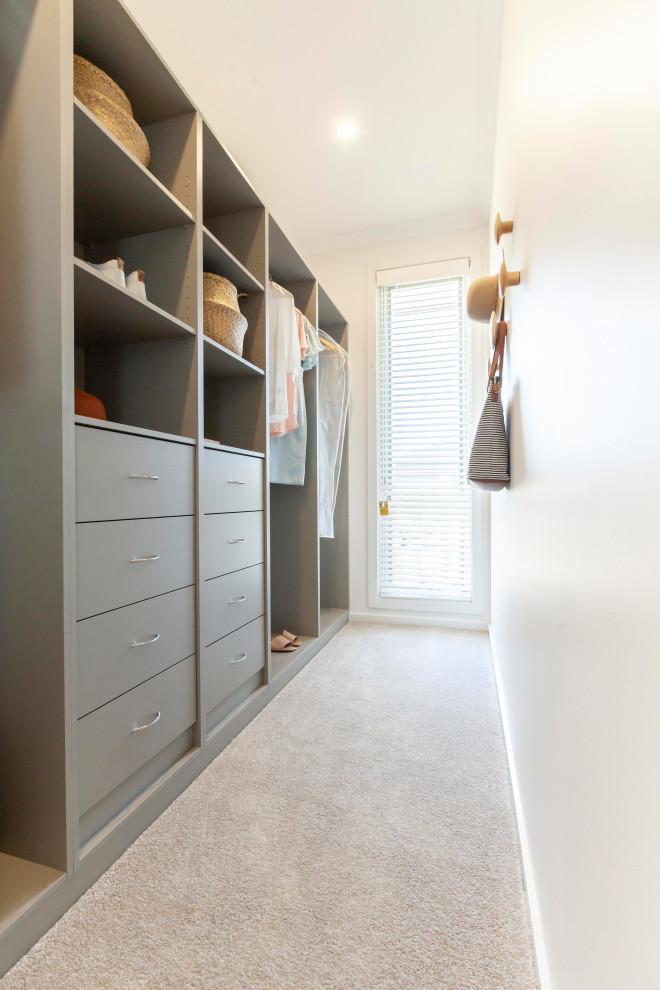 Inspiration for a mid-sized gender-neutral walk-in wardrobe in Melbourne with open cabinets, grey cabinets, carpet and beige floor.