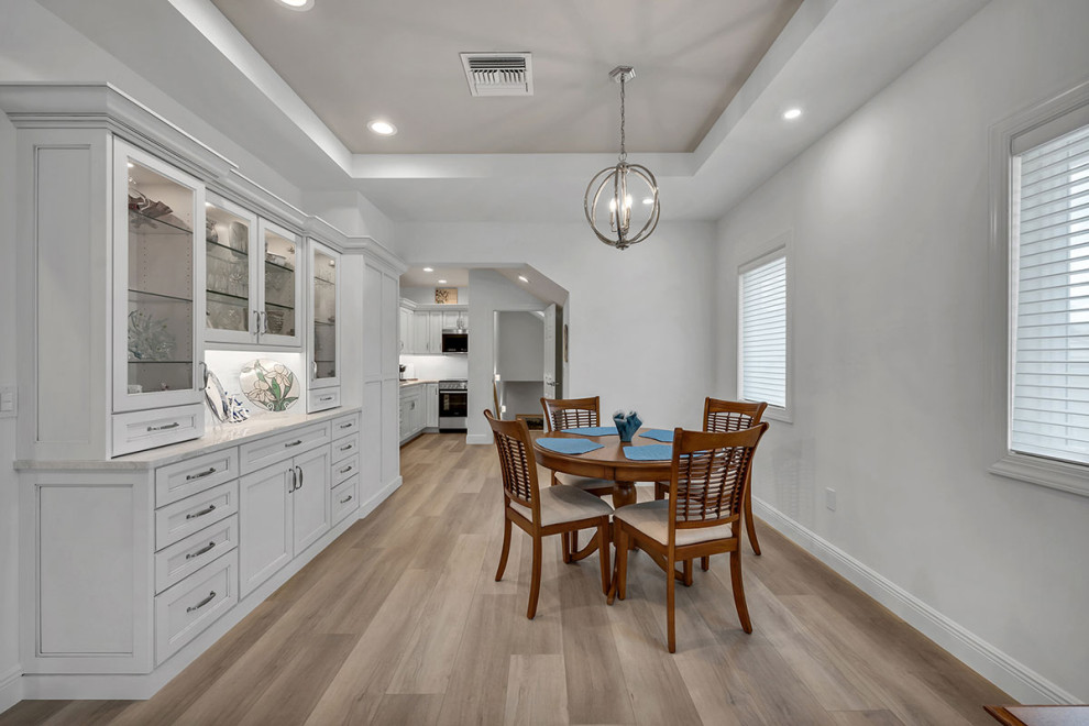 Mid-sized beach style open plan dining in Miami with white walls, light hardwood floors, beige floor and recessed.