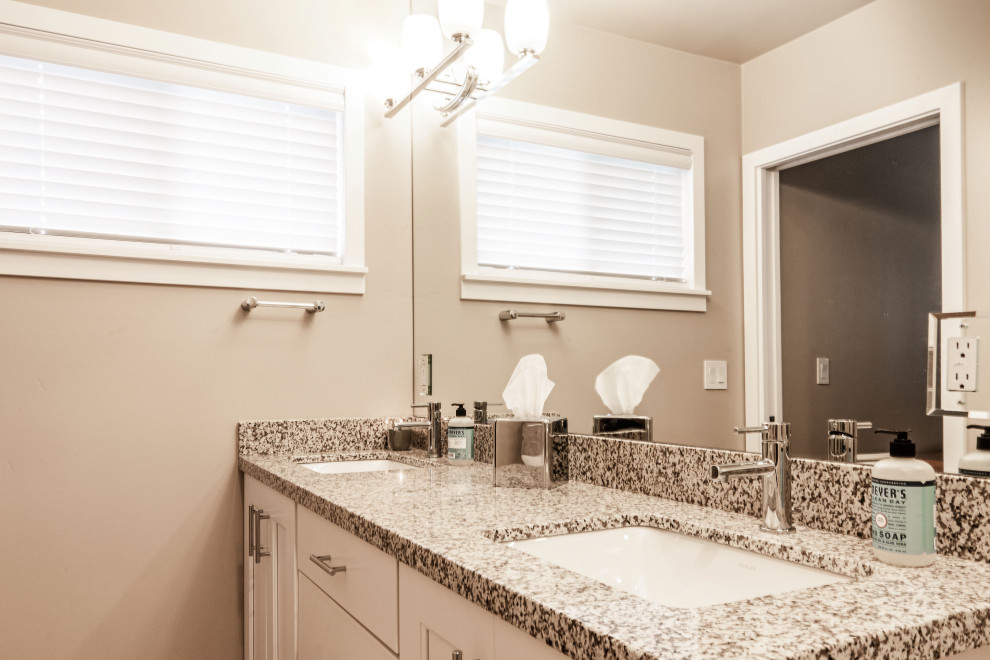 Example of a large transitional medium tone wood floor and red floor open concept kitchen design in Phoenix with an undermount sink, shaker cabinets, white cabinets, granite countertops, multicolored backsplash, granite backsplash, stainless steel appliances, an island and multicolored countertops