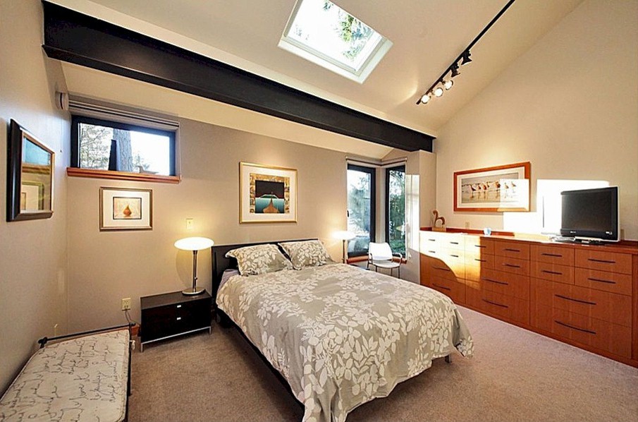 Mid-sized industrial guest bedroom in Seattle with beige walls, carpet and no fireplace.