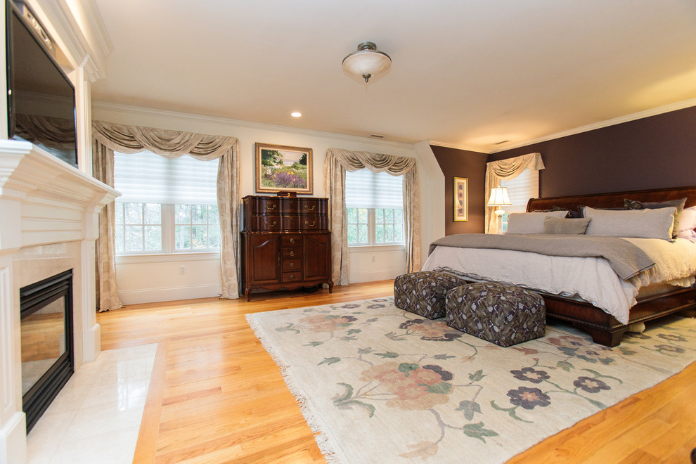 Expansive traditional master bedroom in Boston with brown walls, carpet, a standard fireplace, a wood fireplace surround and beige floor.